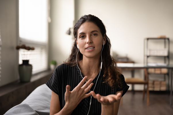 Female instructor wearing earphones asking for training feedback during an online session