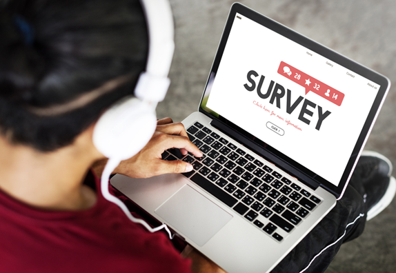 Person wearing headphones using a laptop to complete a training feedback